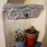 Notiamo ad esempio ci� che rimane di una fonte battesimale in pietra scura con decorazione floreale